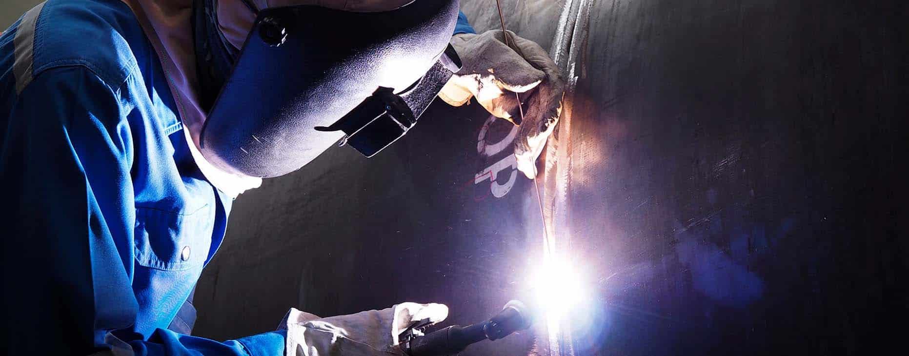 Skilled Welder Holding Electrode for Joining Metal Pieces — Fabrication & Engineering in Mackay, QLD