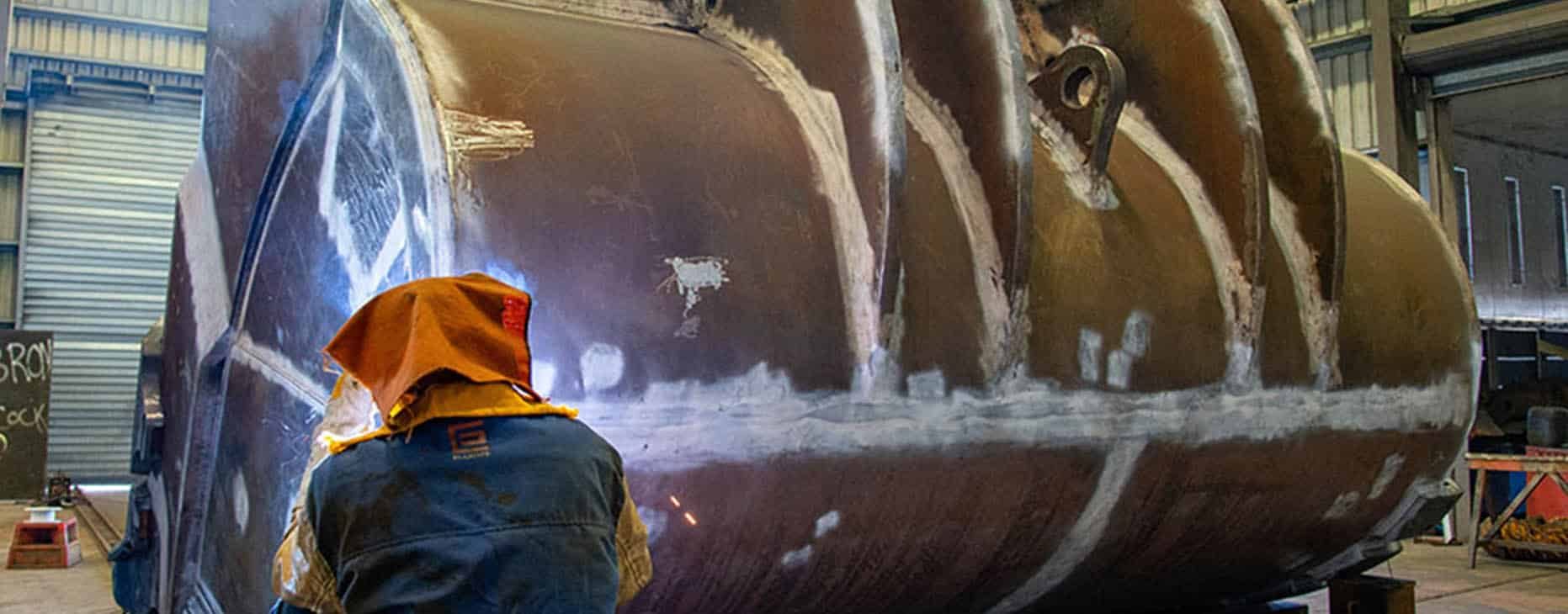 Worker Rebuilding Excavator Claw — Fabrication & Engineering in Mackay, QLD